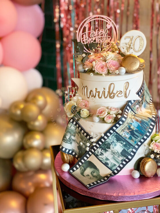 Tarta decorada 70 años carretes de fotos y flores naturales